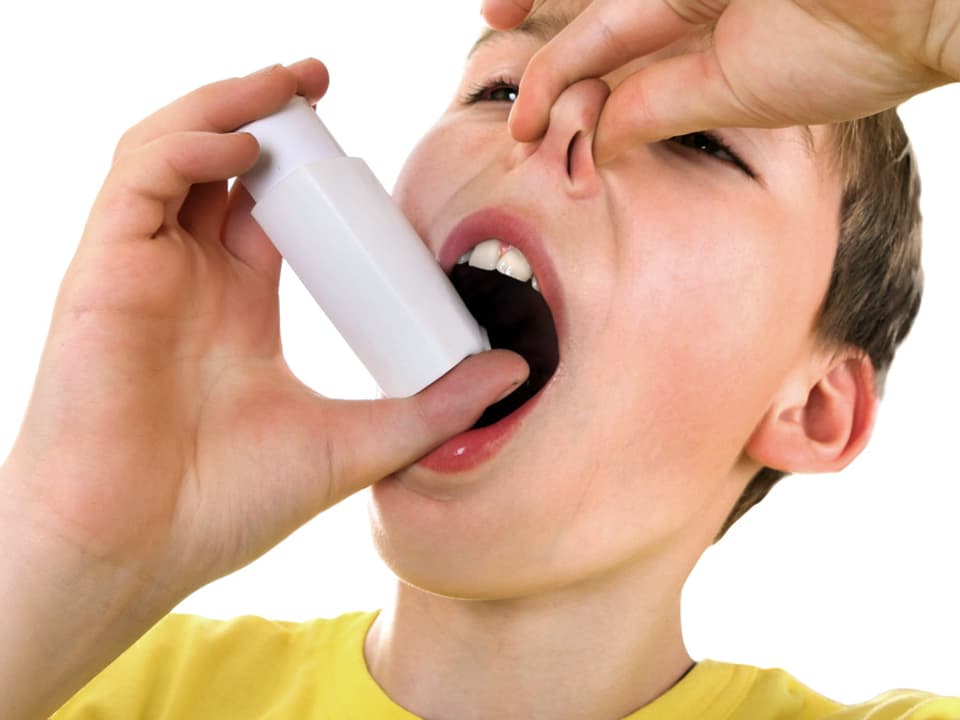 Junge benutzt einen Inhalator kreuzfalsch