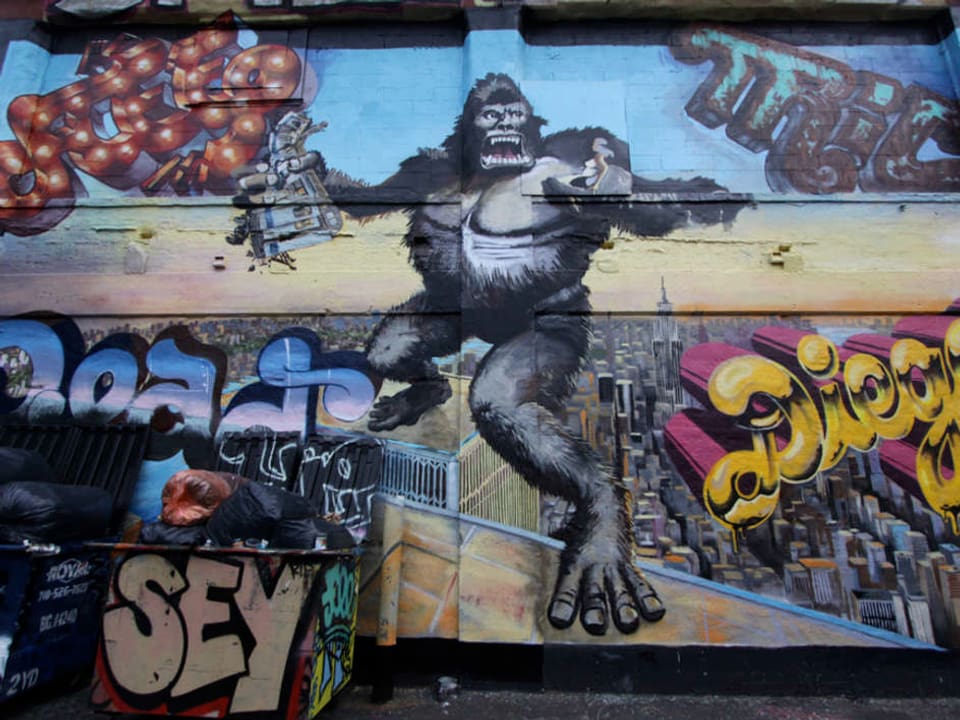 Wandgemälde mit einem Gorilla, der auf einem Hochhaus steht