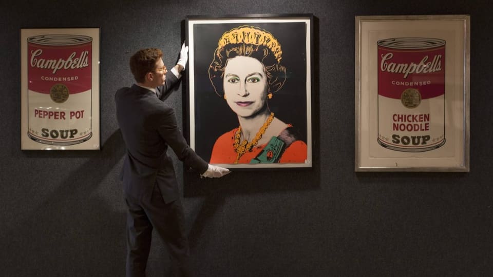 A man adjusts the photo with the queen.  On the right and left is a white and red image of a can.