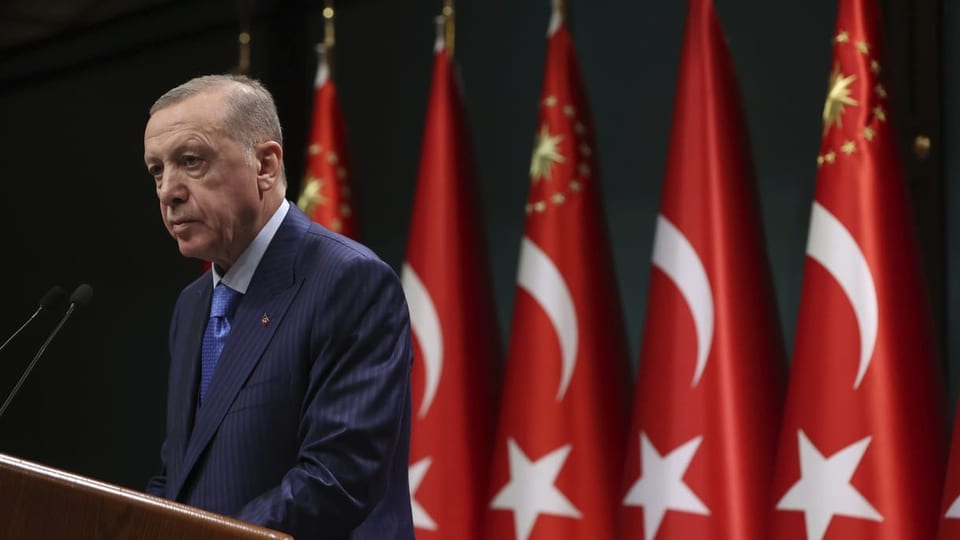 Recep Tayyip Erdogan am Rednerpult, hinter im türkische Flaggen.