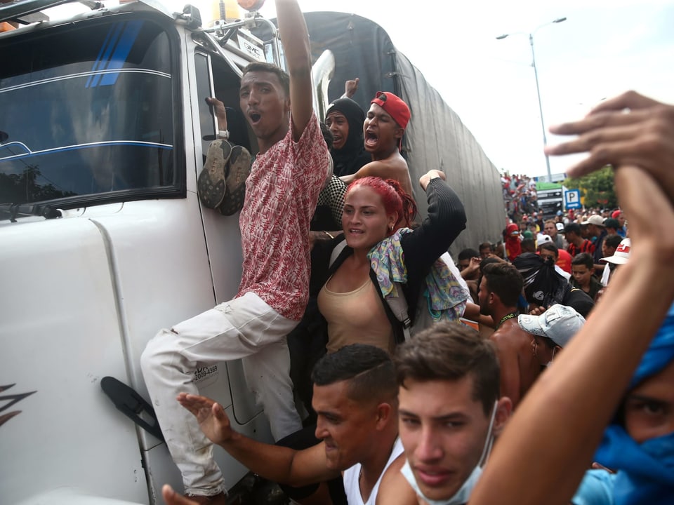 Demonstranten hängen sich an einen Lastwagen.