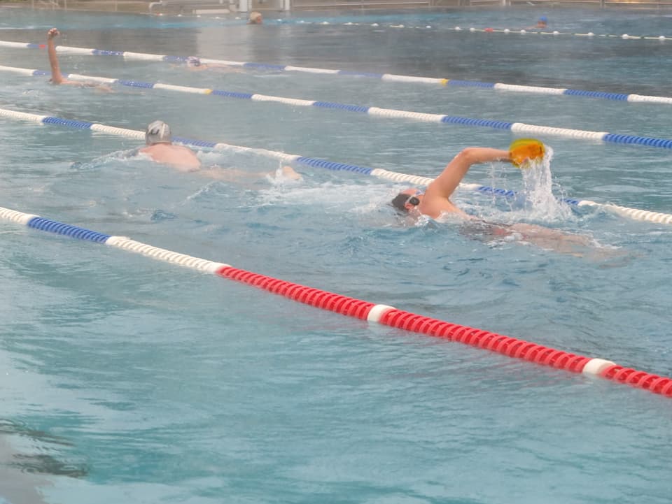Wasserbecken mit rot/blau/weissen Absperrungen, zwei Schwimmer am schwimmen