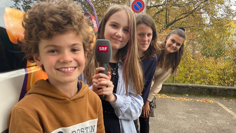 Drei Kinder mit SRF Kids Moderatorin Angela Haas