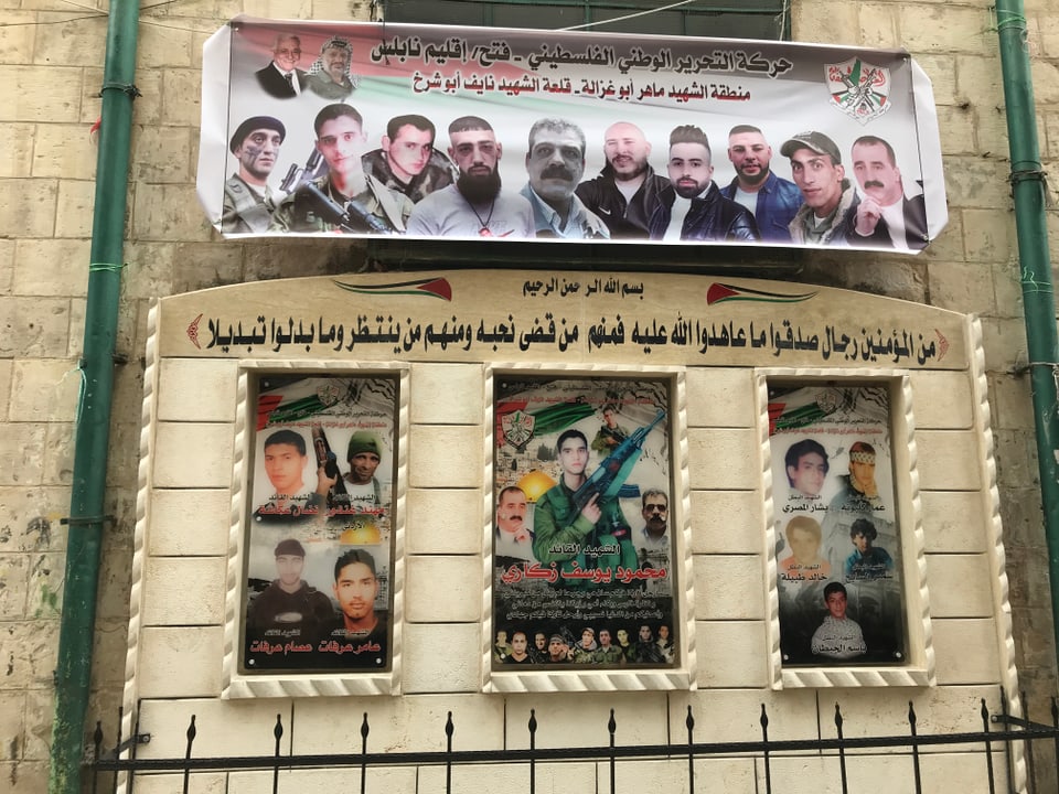 Bilder gefallener palästinensischer Kämpfer an einer Mauer.