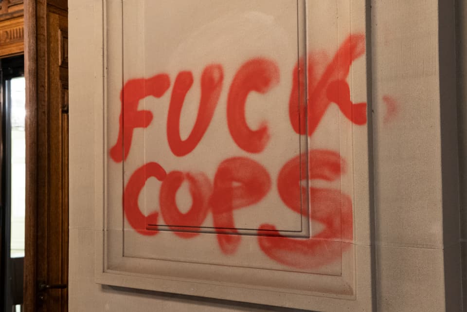 Eine Tür mit einer Sprayerei: Fuck, Cops.