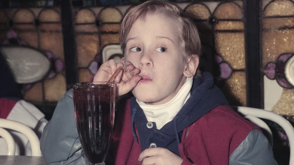Macaulay Culkin trinkt eine Cola. 