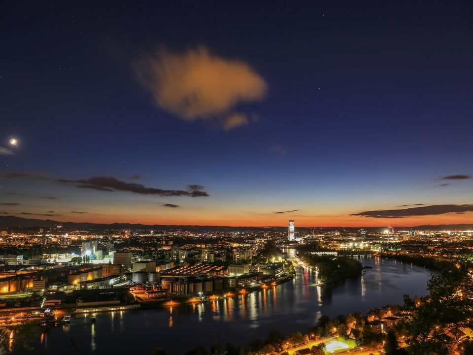 Blick auf Basel mit Lichtermeer und Rhein. 