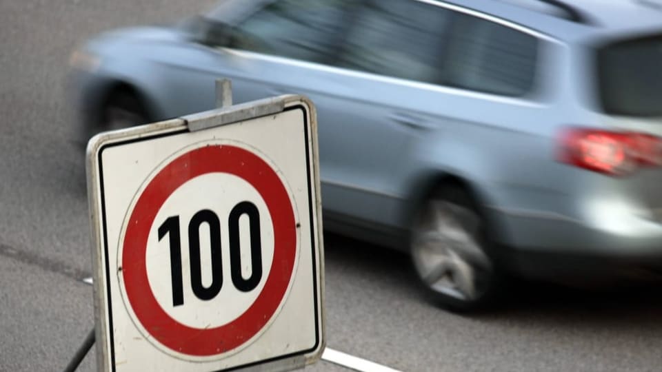 Ein Auto fährt an einem 100 km/h-Schild vorbei