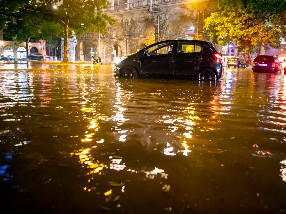 Auto in überfluteter Strasse.