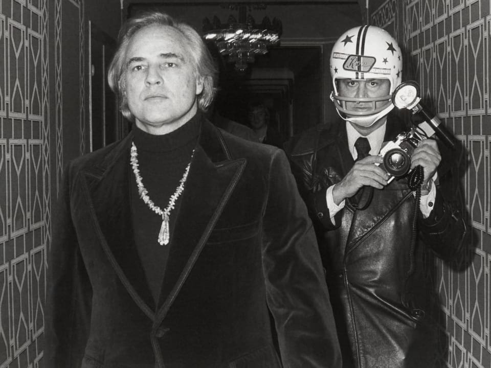 Marlon Brando und Ron Galella mit Helm.