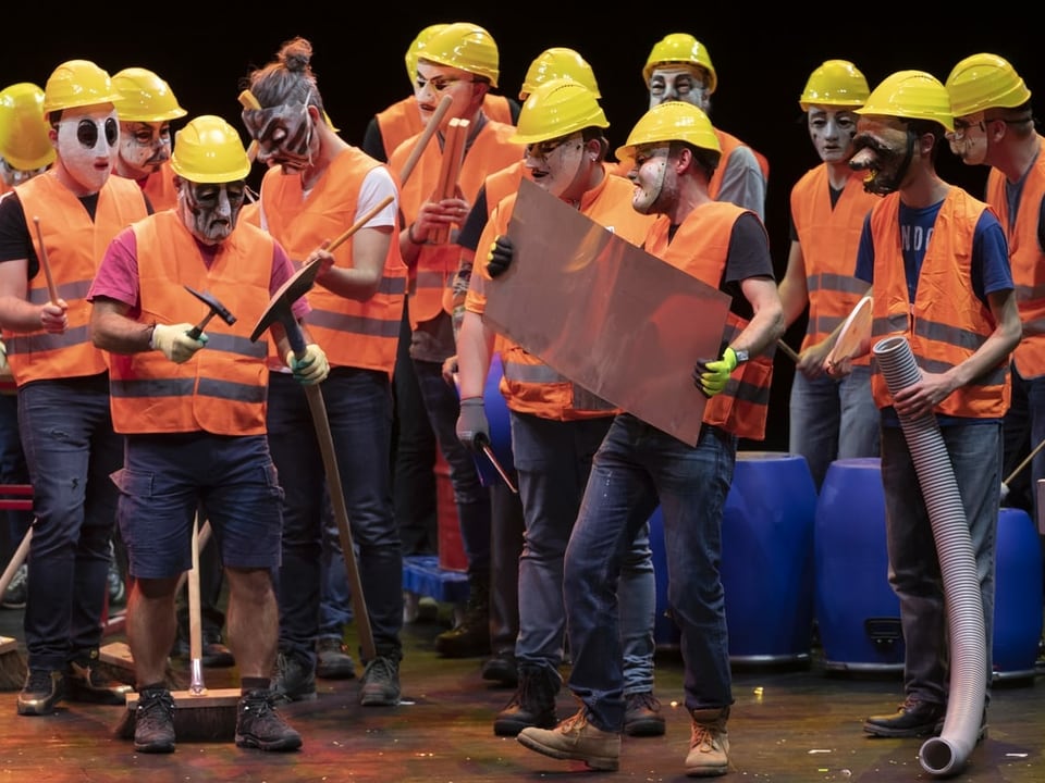 Arbeiter in orangen Grillette und gelben Helmen spielen auf ihren Werkzeugen.