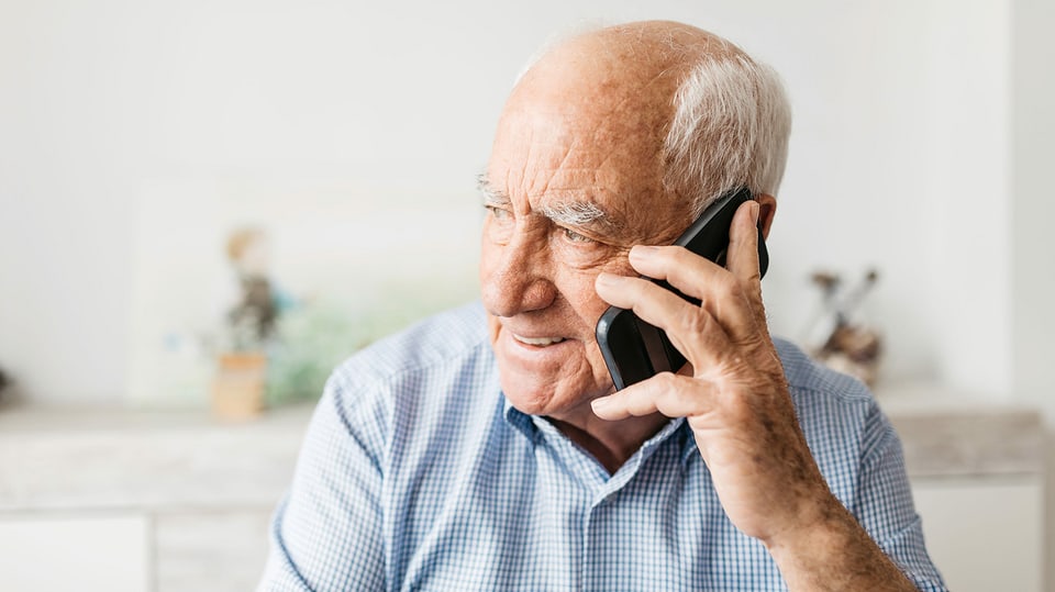 Ein älterer Mann am Telefon.