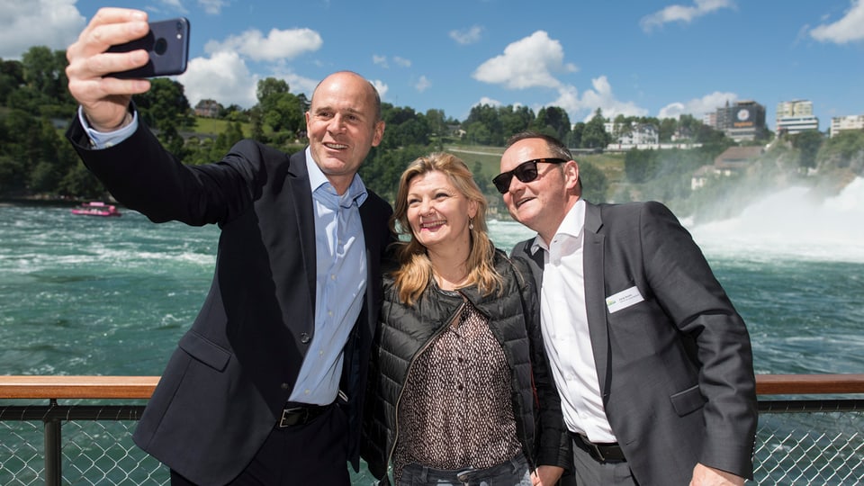 Zwei Männer und eine Frau beim Selfie vor dem Rheinfall.