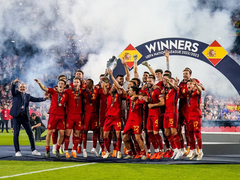 Seleção espanhola de futebol comemora vitória da UEFA Nations League 2022/2023 com troféu.