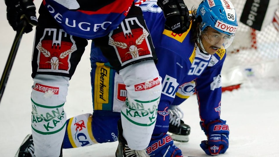Eishockeyspieler der National League A. Ihre Hosen und Schoner zieren Bierwerbung.