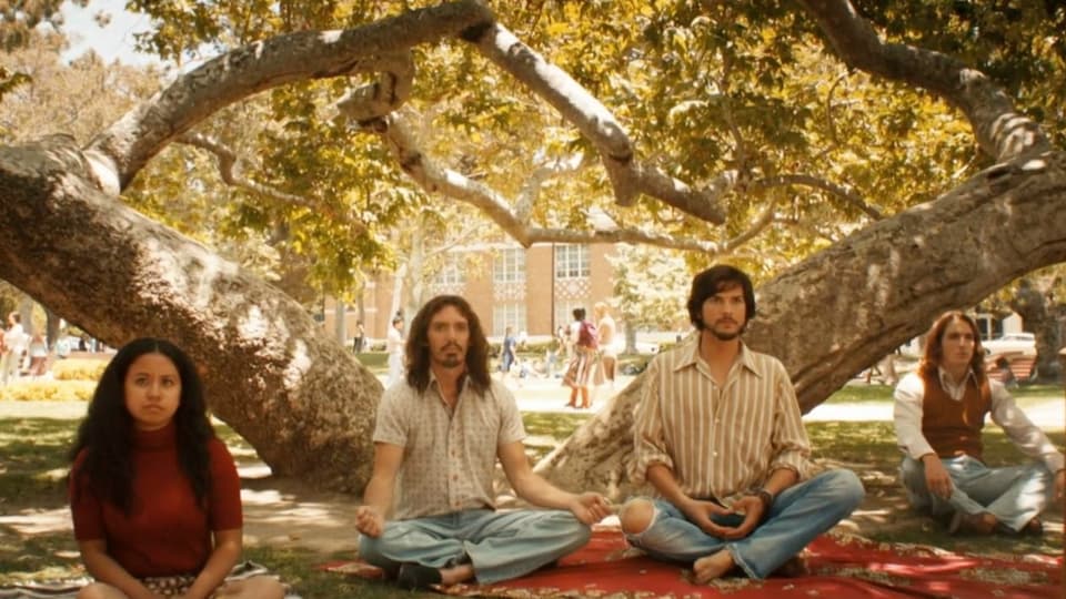 Aston Kutcher als Steve Jobs in Gruppe meditierend.