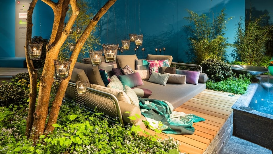 Eine Lounge mit vielen Kissen und Lampen neben einer Wasserwelt