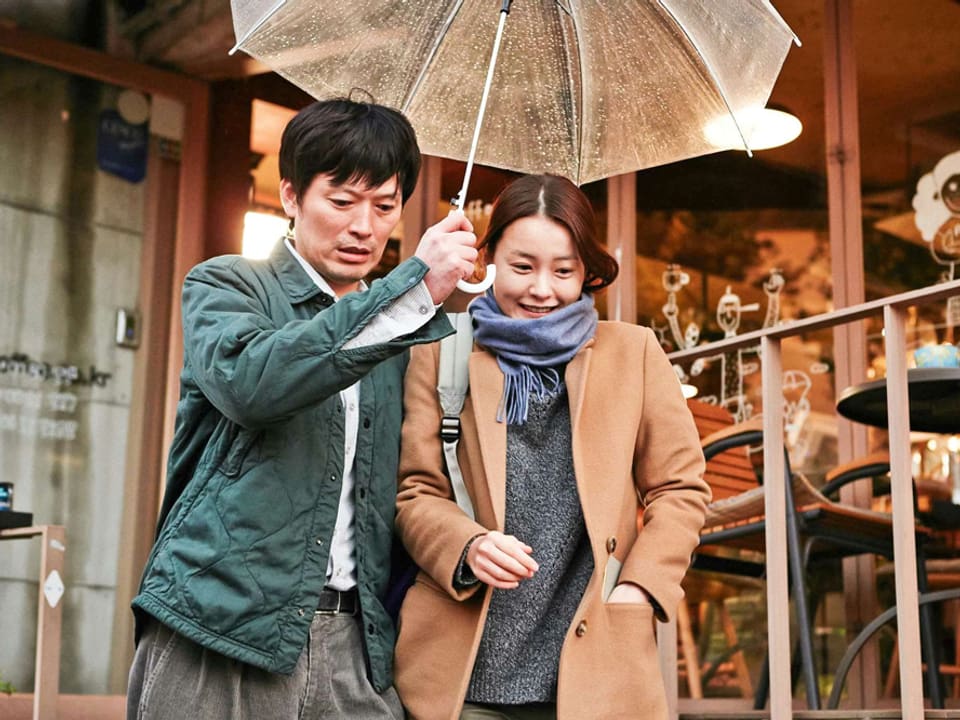 Sunhi und Jae-Hak unter einem Regenschirm.