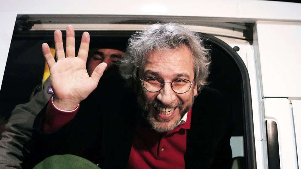 Can Dündar verlässt ein Polizeiauto auf dem Weg zum Gerichtssaal.