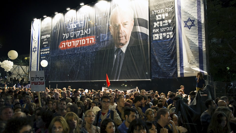 Gedenken in Tel Aviv. Viele Menschen im Vordergrund, hinten ein grosses Plakat mit dem Gesicht Rabins. 