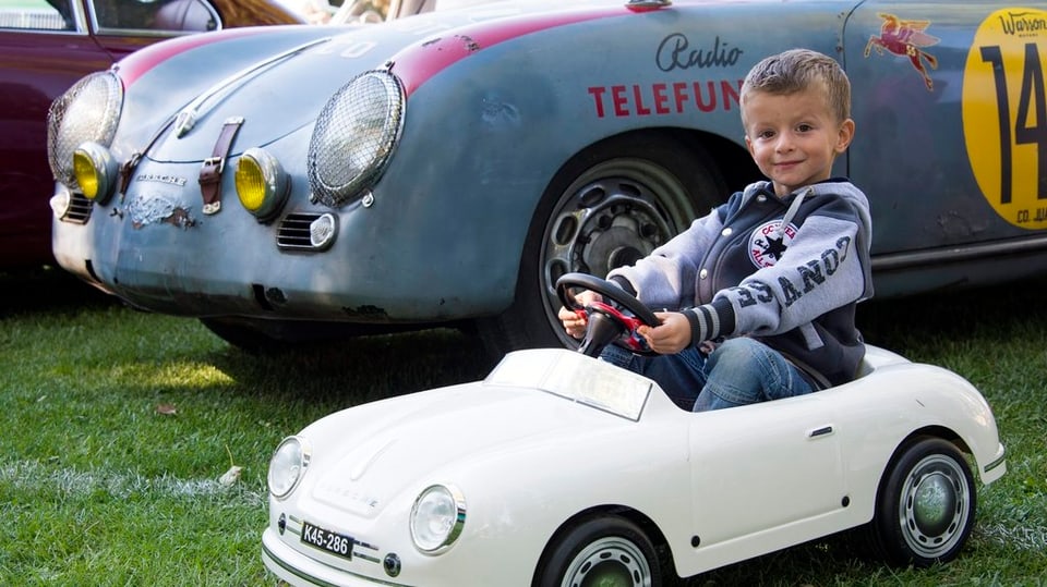 Ein kleiner Junge in einem kleinen Oldtimer-Auto