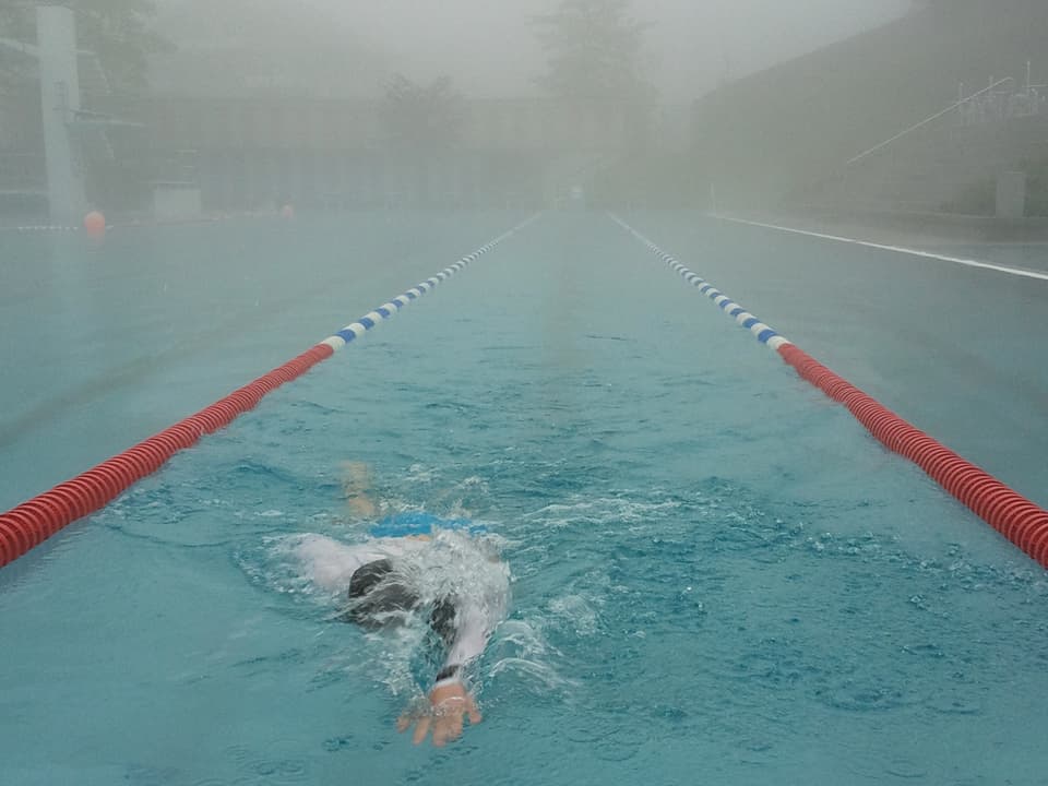 Ein Schwimmer in Neopren in einem Schwimmbecken.