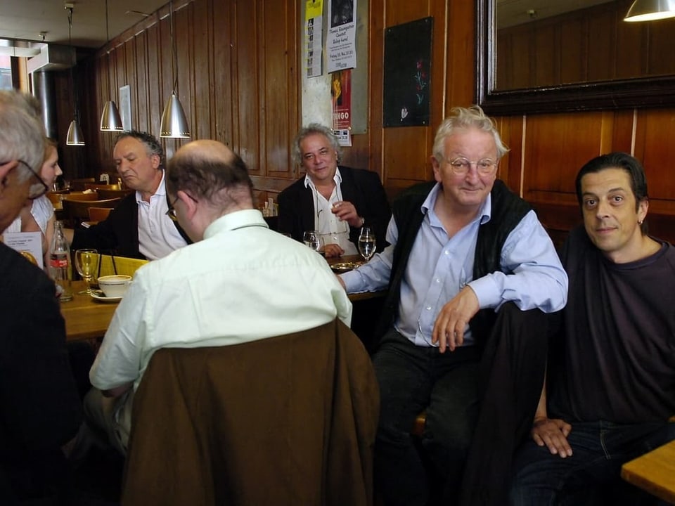 Menschen sitzen in einem traditionellen Restaurant beim Essen und Gespräch.