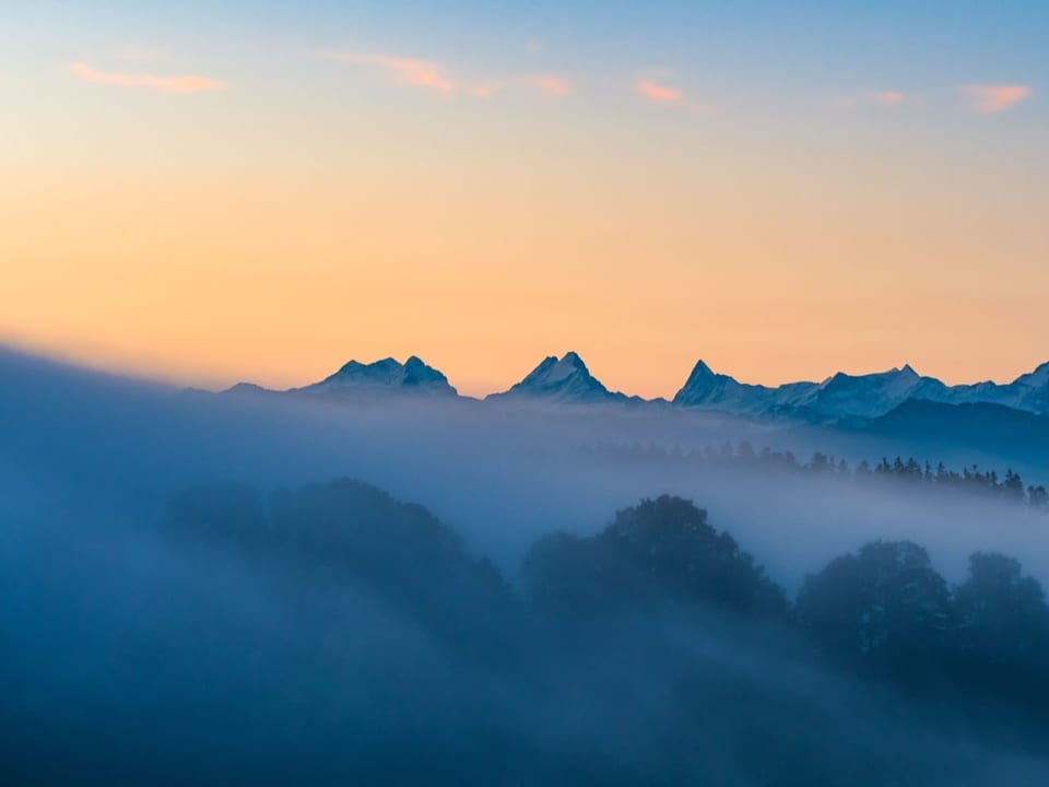 Nebelfelder über der Ebene, Berge im Hintergrund