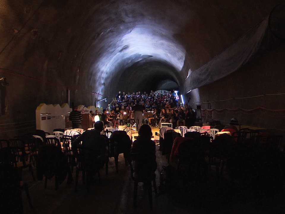 Ein Chor probt in einem spärlich beleuchteten Tunnel.