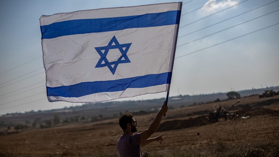 Ein Mann schwenkt mit der israelischen Flagge.