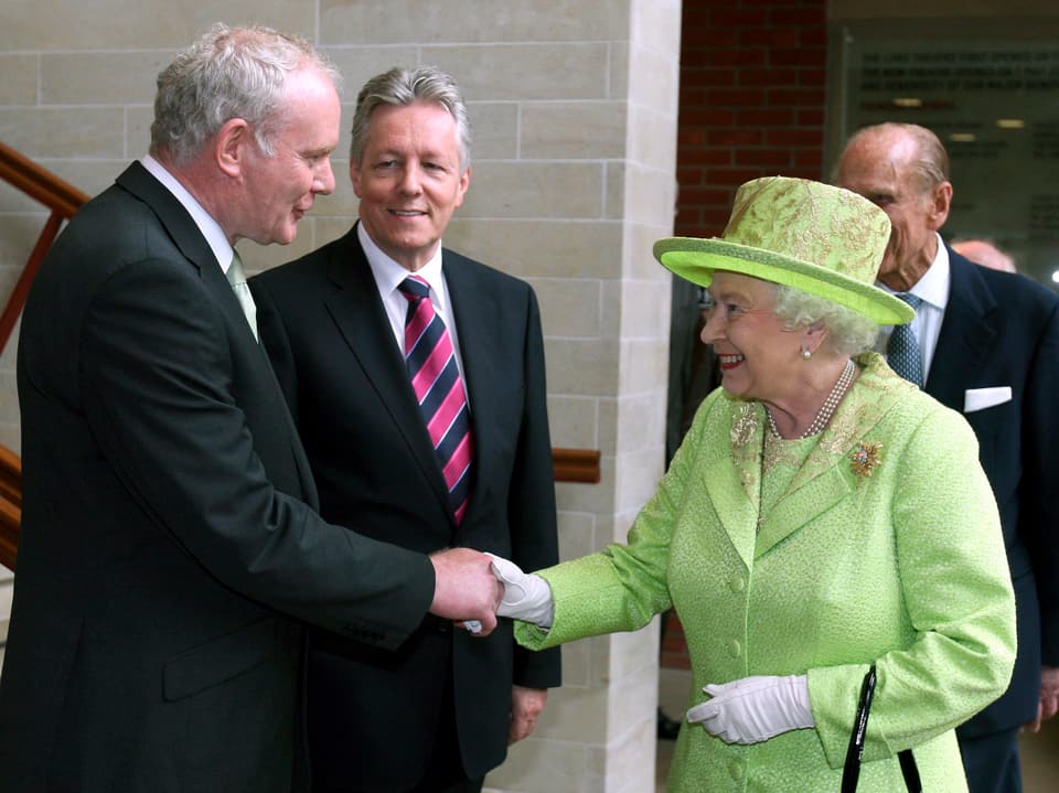 McGuinnes und die Queen schütteln sich die Hände.