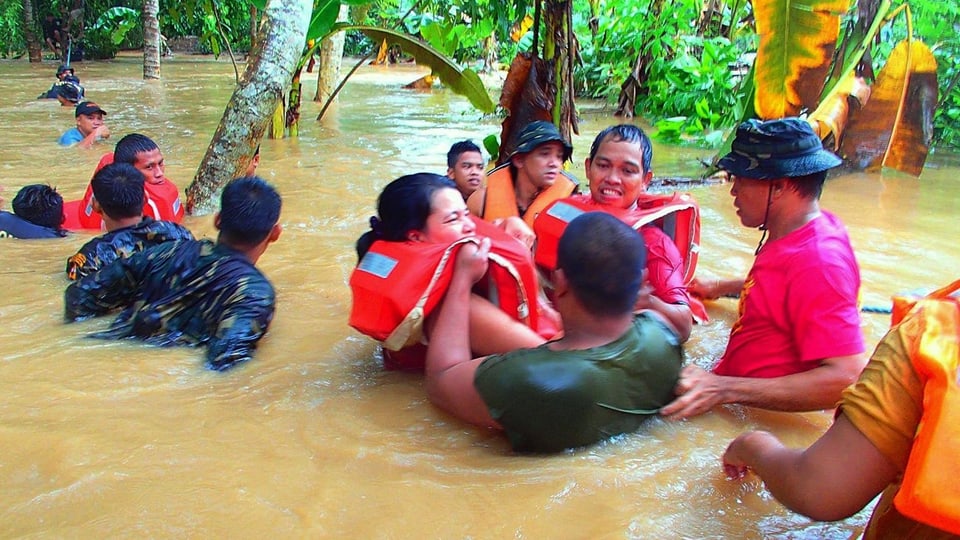 Menschen schwimmen in Hochwasser auf den Philippinen