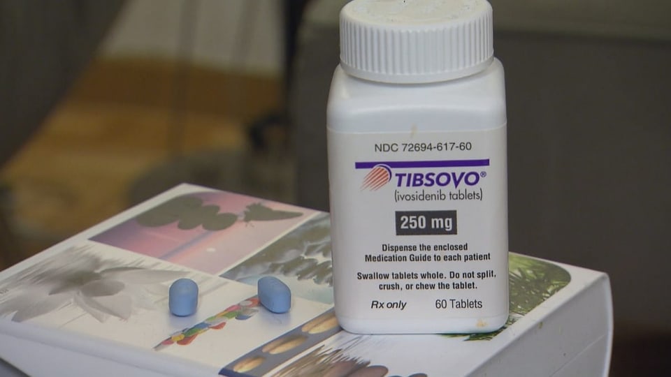 Eine Medikamentendose «Tibsovo» mit zwei blauen Tabletten befinden sich auf einem Buch.