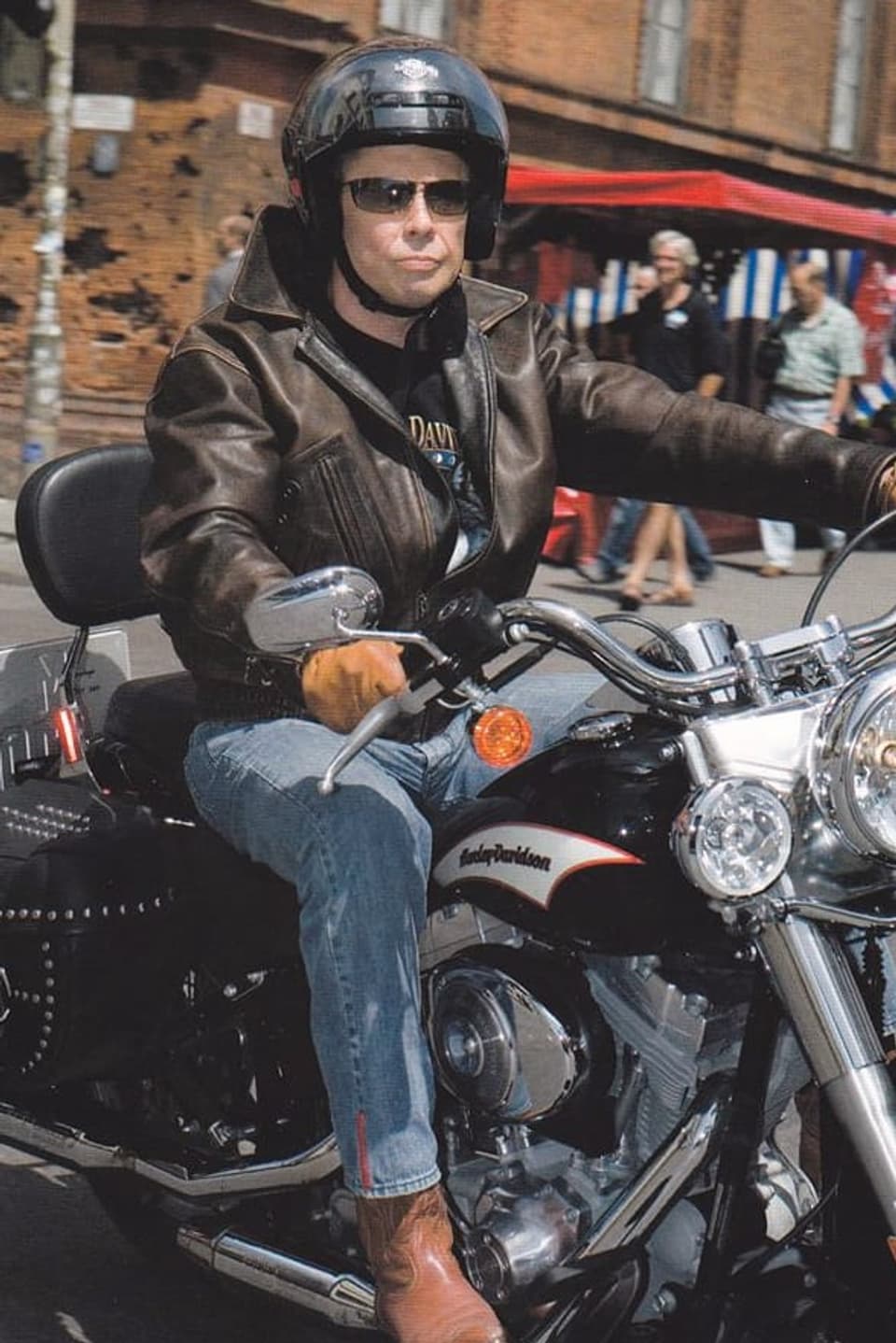 Peter Kraus in Lederkluft und mit Helm auf Harley Davidson.