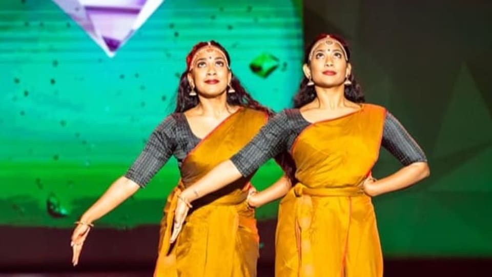Mithuja und Janusha Amirthalingam tanzen synchron nebeneinander auf der Showbühne.