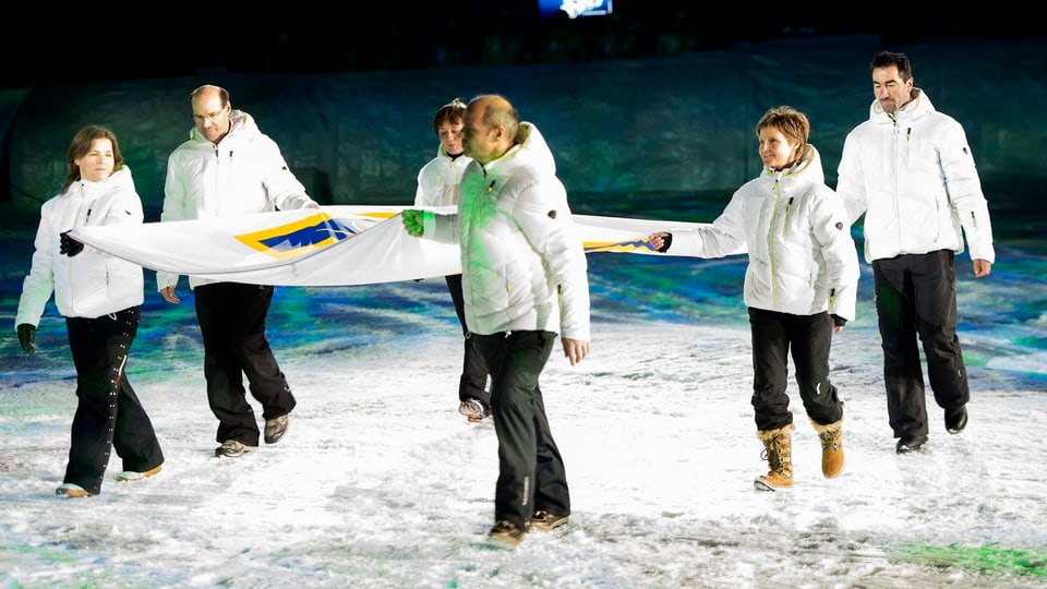 Erika Hess (2. von rechts) beim Einmarsch ins Stadion mit der FIS-Fahne.