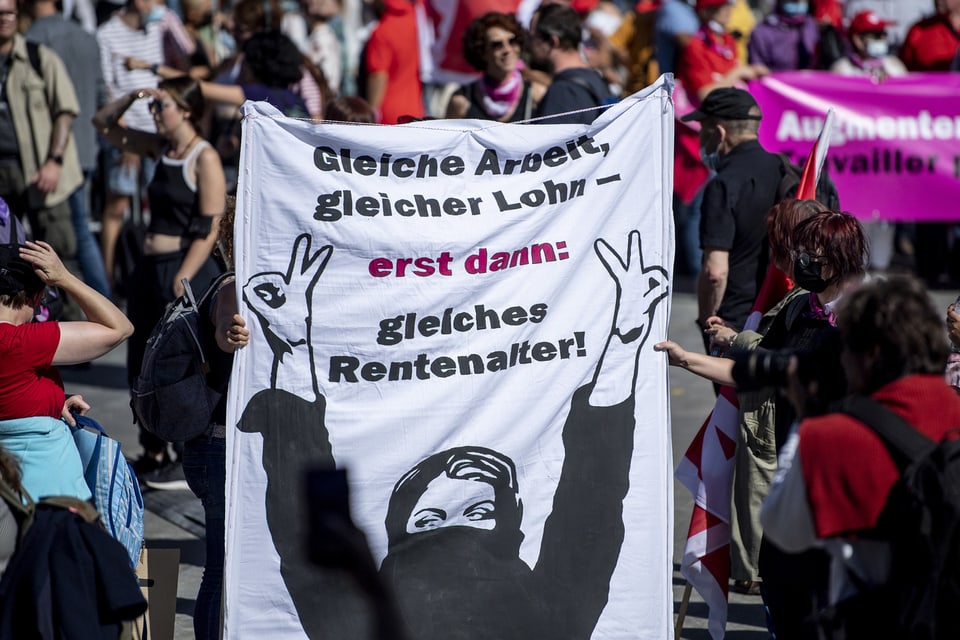 Frauen halten ein Transparent in die Höhe.