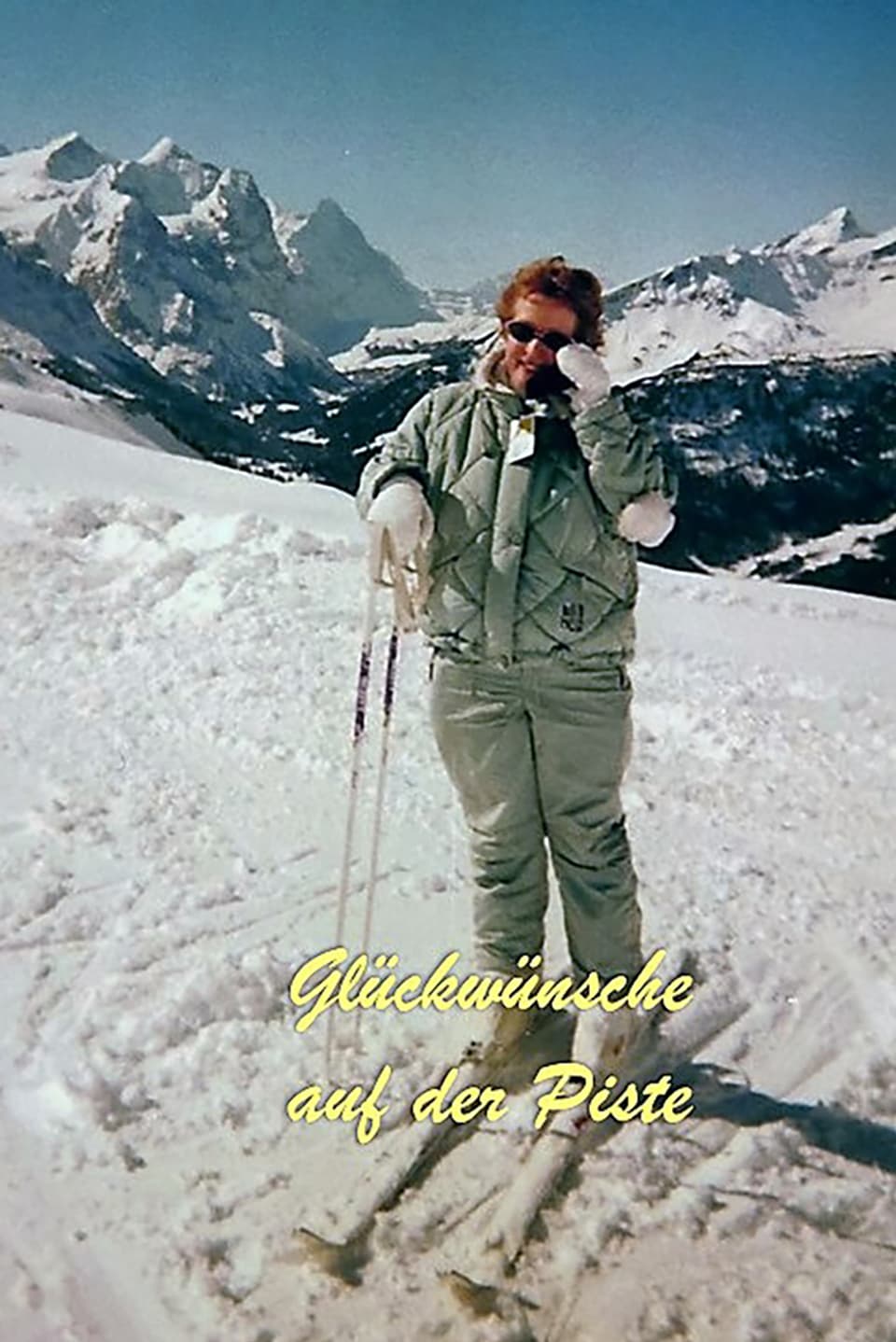 Ein Mann in einem Oliv-farbigen Skianzug. 