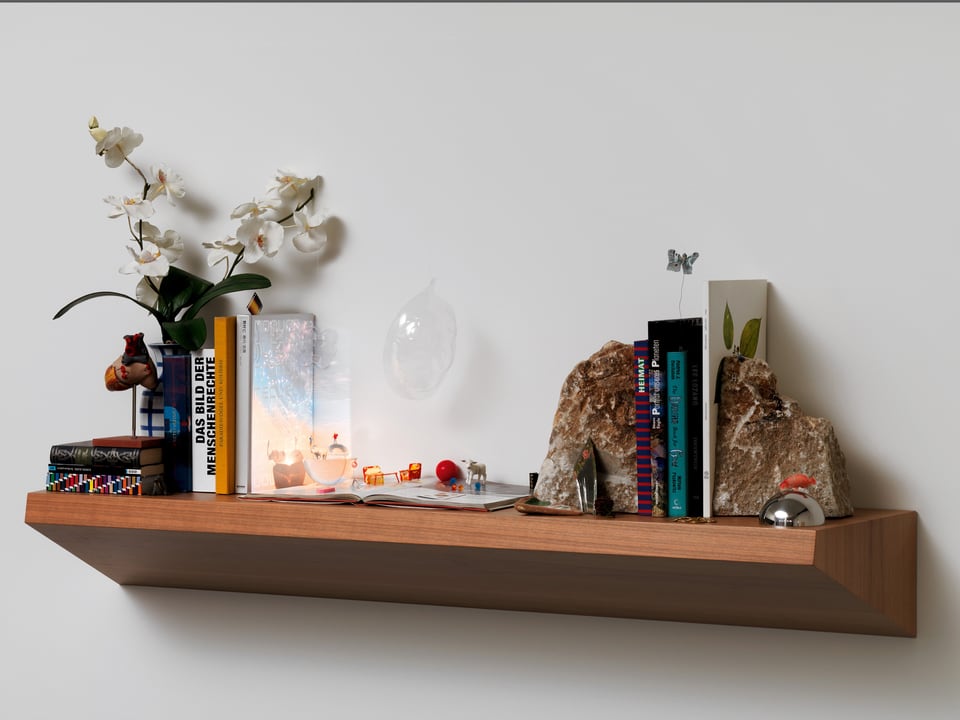 Ein Wandtablar mit Büchern, Orchideen und weiteren Gegenständen.