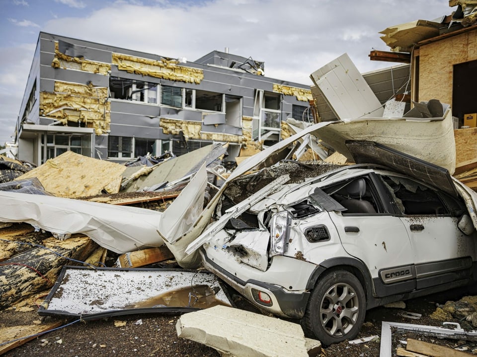 Ein zersquetschtes Auto in Mitten von Trümmern nach dem Sturm in La Chaux-de-fonds (24.07.23