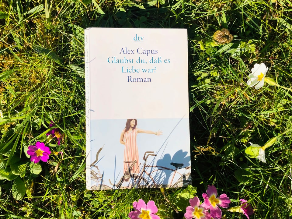 Alex Capus Roman «Glaubst Du, dass es Liebe war» liegt auf Gras