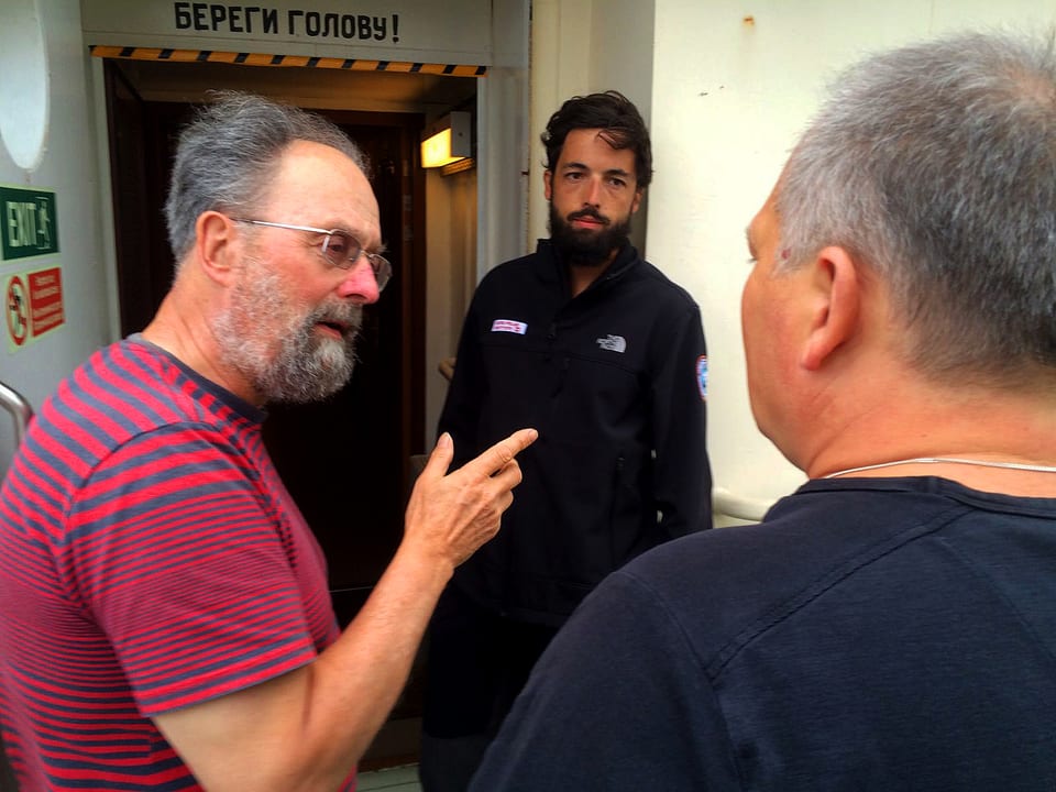 Bordmeteorologen, Victor Veledin, bespricht sich mit dem wissenschaftlichen Expeditionsleiter David Walton und mit Pascal Graf auf Deck der «Akademik Tryoshnikov».
