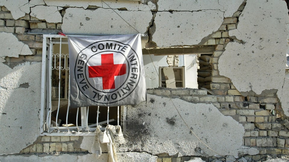 Eine IKRK-Fahne an einem zerstörten Gebäude in Bagdad (Archiv).