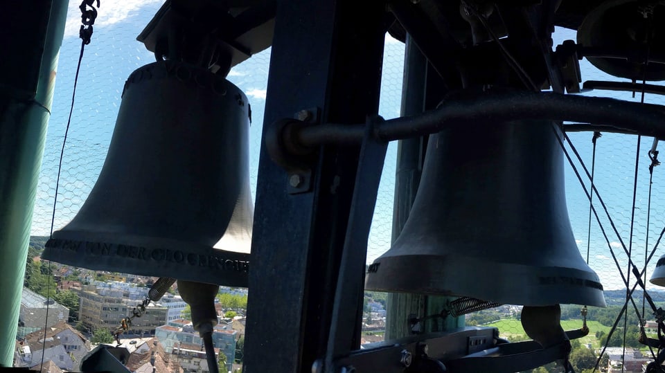 Glocken in einem Turm über einer Stadt.