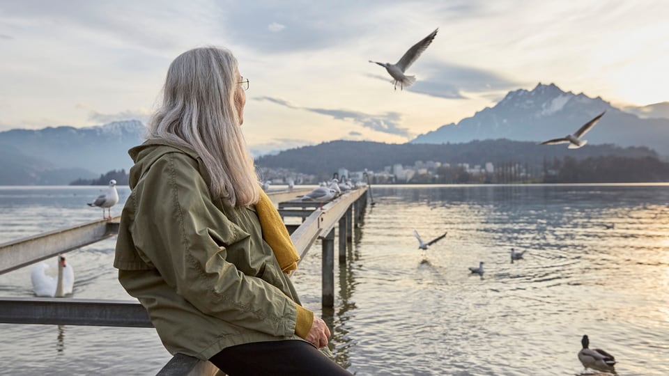 Eine ältere Frau blickt nachdenklich auf den Vierwaldstättersee.
