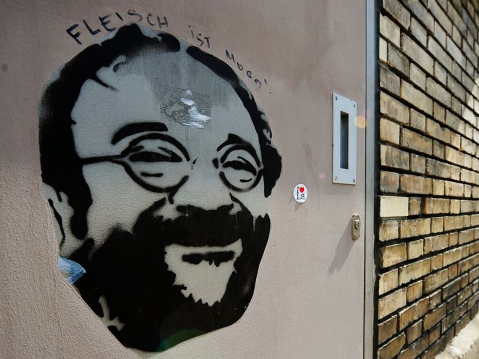 Ein Graffiti eines Mannes mit Bart und Brille.