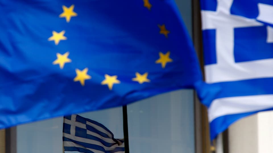 EU-Fahne weht neben zwei Griechenfahnen