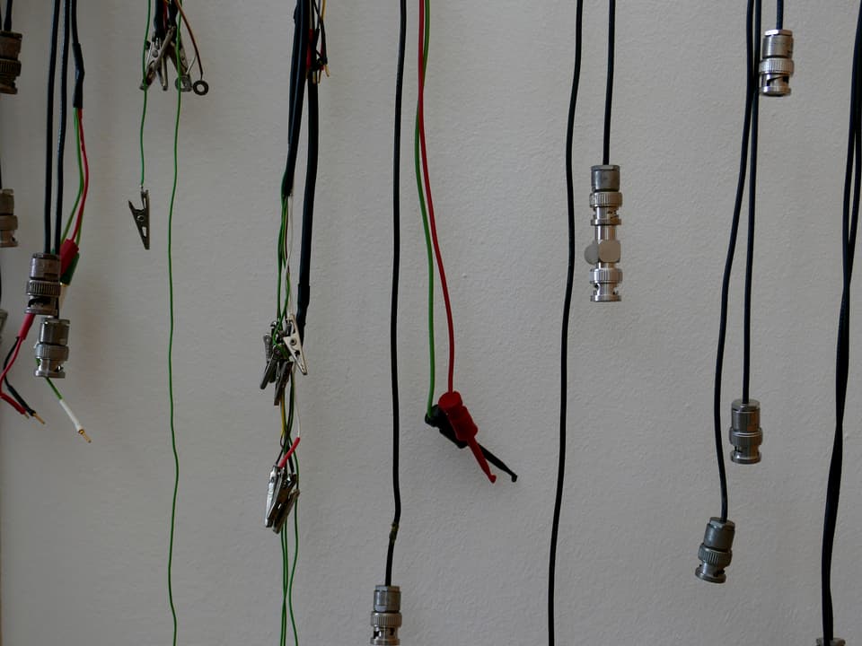 Kabel hängen an einer Art Garderobe