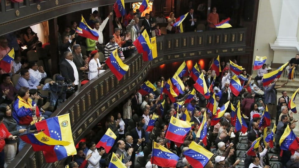 Mitglieder der Verfassungsgebenden Versammlung schwenken venezolanische Flaggen während einer Sitzung.