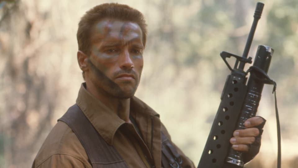 Ein Mann mit Camouflage-Make-Up hält ein Gewehr